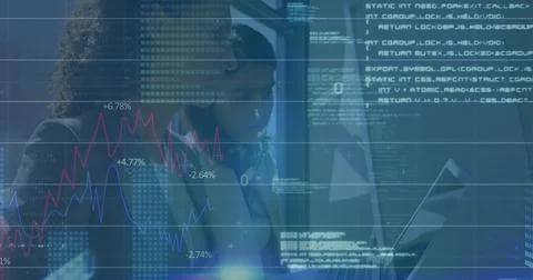 Two analysts wearing jackets examining digital display in lab, with line charts Stock Photos
