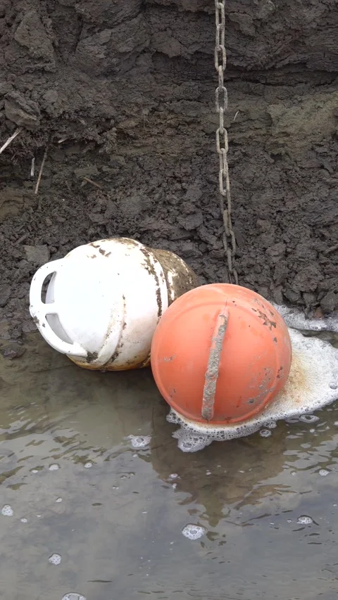 Two anchor floats on the bottom of Lake Domaa during a water shortage Stock Footage 303247464