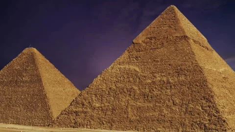 Two ancient Egyptian pyramids stand tall against a dramatic sunset sky. Stock Footage 306745898