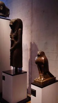 Two ancient egyptian statues, representing sekhmet and horus, stand on podi.. Stock Photos