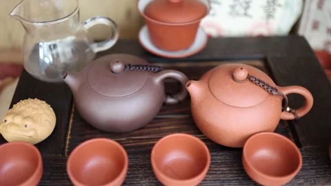 Two ancient Yixing teapots rest upon a wooden altar, their silent whispers carry Stock Footage 304623371