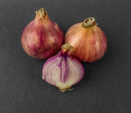 Two and a half medium size fresh and ripe red onion isolated on a white backg Stock Photos