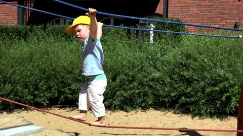 Two and half year old blond cute boy playing at children playground Stock Footage 104727288