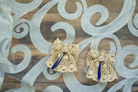 Two angels made of light brown lace on the table Stock Photos