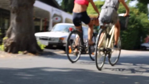Two anonymous gils riding bikes sunny day Stock Footage 112854699