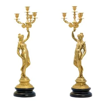 Two antique golden candlesticks in the shape of female figures. Isolated picture Stock Photos