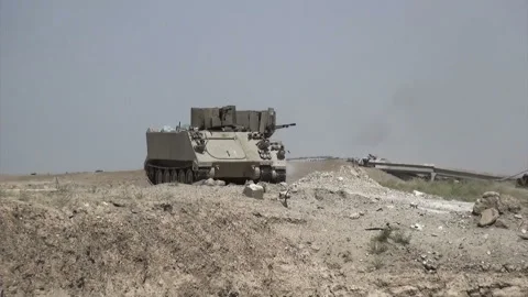 Two APCs shooting towards ISIL fortifications at Fallujah outskirts, Iraq Stock Footage 148899708