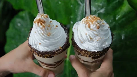 Two appetizing milkshakes with whipped cream with metal tubes for a cocktail are Stock Footage 171854017