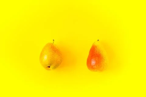 Two appetizing ripe pears with red side on a yellow background. Stock-Fotos