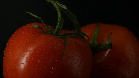 Two appetizing ripe tomatoes on a mirror black background. Rotating table 動画素材 108909027