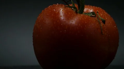 Two appetizing ripe tomatoes on a mirror black background. Rotating table 動画素材 108909032