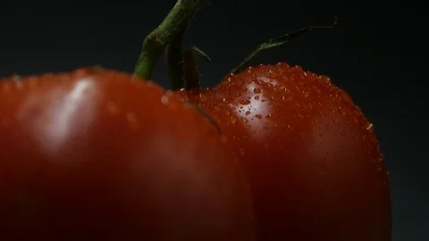 Two appetizing ripe tomatoes on a mirror black background. Rotating table 動画素材 108909039