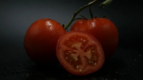 Two appetizing ripe tomatoes on a mirror black background. Rotating table 動画素材 108909267