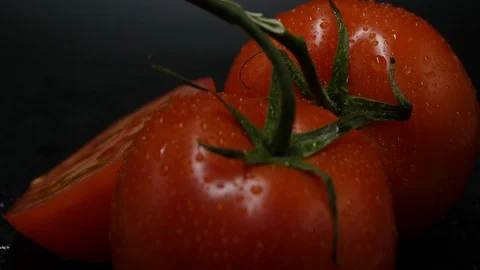 Two appetizing ripe tomatoes on a mirror black background. Rotating table 動画素材 108909271
