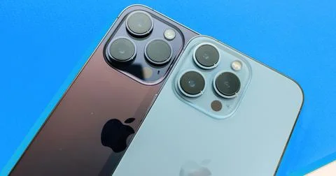 Two Apple iPhones Against Yellow BG Stock Photos