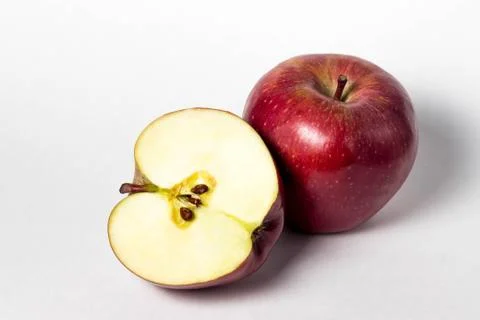 Two apple on a white background. One apple is whole.  Stock Photos