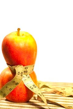 Two Apples Balanced with a Tape Measure Waist Vertical Stock Photos