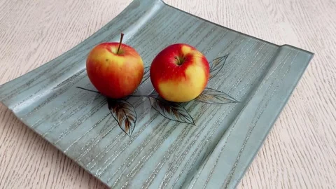 Two Apples on Decorative Plate with Leaf Pattern on Wooden Table Stock Footage 330359088