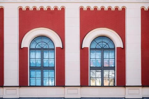 Two arched windows on a brick wall. Stock Photos