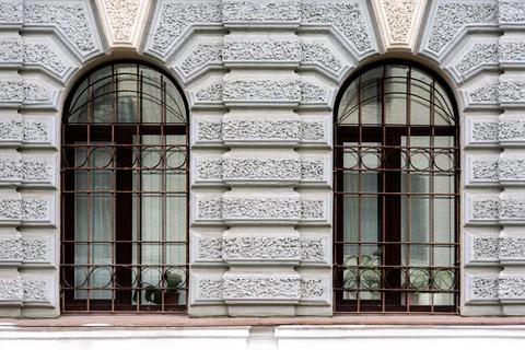 Two arched windows with grilles. Stock Photos