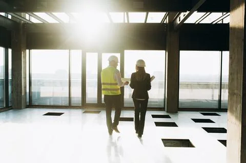 Two architect engineers are walking in a constructed office building. Foto stock