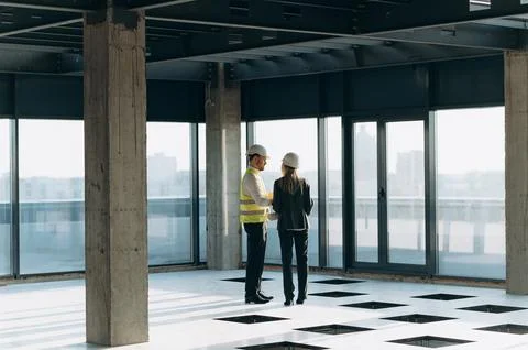 Two architect engineers are walking in a constructed office building. Foto stock