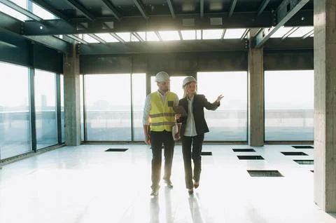 Two architect engineers are walking in a constructed office building. Foto stock