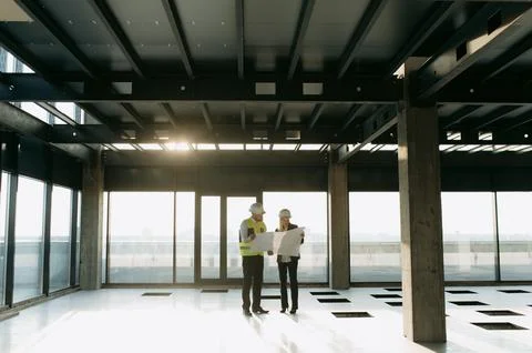 Two architect engineers are walking in a constructed office building. Fotos de archivo