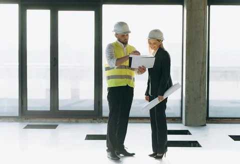 Two architect engineers talking in a constructed office building. implement.. Stock Photos