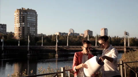 Two architects are standing at the building site, the river and are considering Stock Footage 97804909