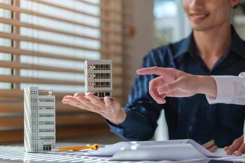 Two architects constructing model of buildings and examining their project .. Stock Photos