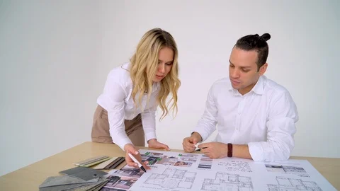 Two Architects Discussing Plan Together At Desk With Blueprints Stock Footage 88640502