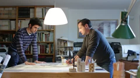Two architects examining a plan in an office (dolly) Stock Footage