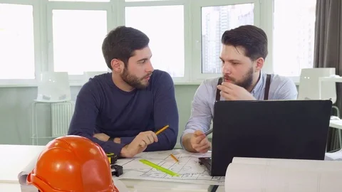 Two architects gesture at the table Stock Footage 73911774