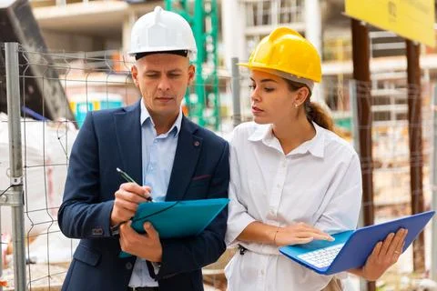 Two architects with laptop discussing construction plan Stock Photos