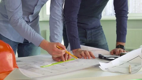 Two architects make marks on the plans of the building Stock Footage 73911140