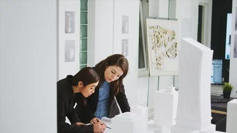 Two architects measuring building scale on blueprint Stock Photos
