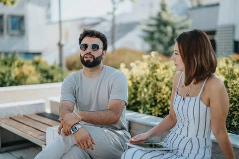 Two architects or designers collaborating outdoors, discussing blueprints and Stock Photos
