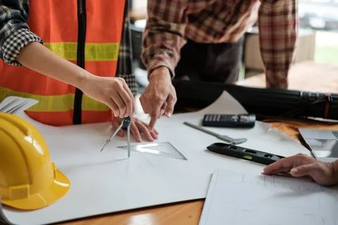 Two architects use a compasses to design the building. Stock Photos