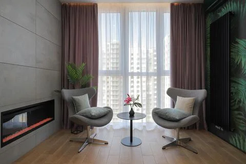 Two armchairs with table and a bio fireplace in the living room Stock Photos
