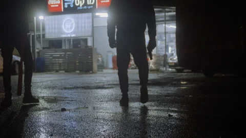 Two armed men standing outside a grocery store at night Stock Footage 275171484