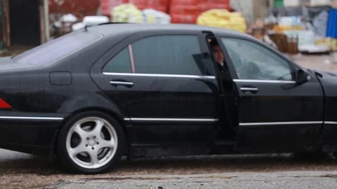 Two armed men with their boss get out of a black car. AK-47. Bodyguards Stock Footage 129420269