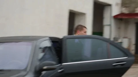 Two armed men with their boss get out of a black car. AK-47. Bodyguards Stock Footage 129420275