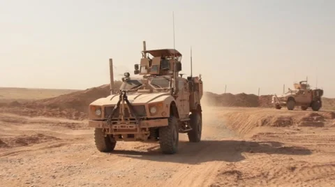 Two armored vehicles MRAP driving out military base, Afghanistan Stock Footage