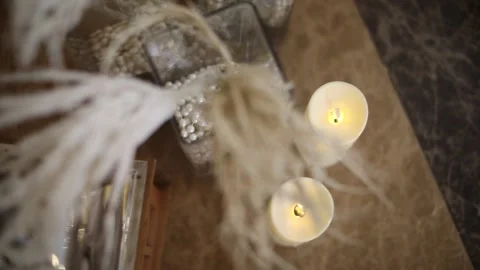 Two artificial candles and decorations burning side by side, on a wooden table Video stock 204000318