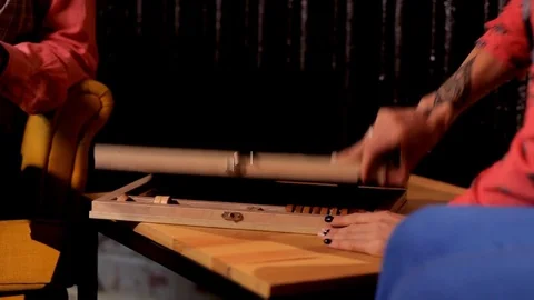 Two artistic girls play backgammon in a restaurant Stock Footage 80843980