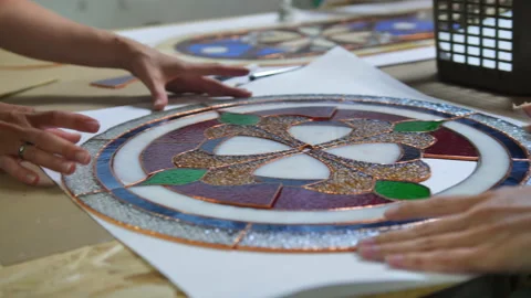 Two artists assemble a composition from stained glass windows. Hands of two Stock Footage 161691285