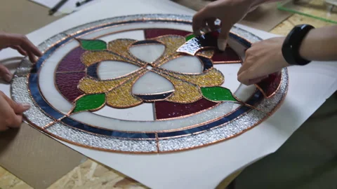 Two artists assemble a composition from stained glass windows. Assembling parts Stock Footage 162093221