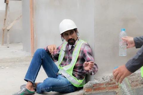 Two Asian builder workers wearing safety reflected vest and helmet tired th.. Stock Photos