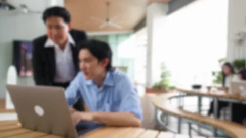 Two Asian Businessmen Discussing Work on Laptop in Bright Modern Office Stock Footage 346036083